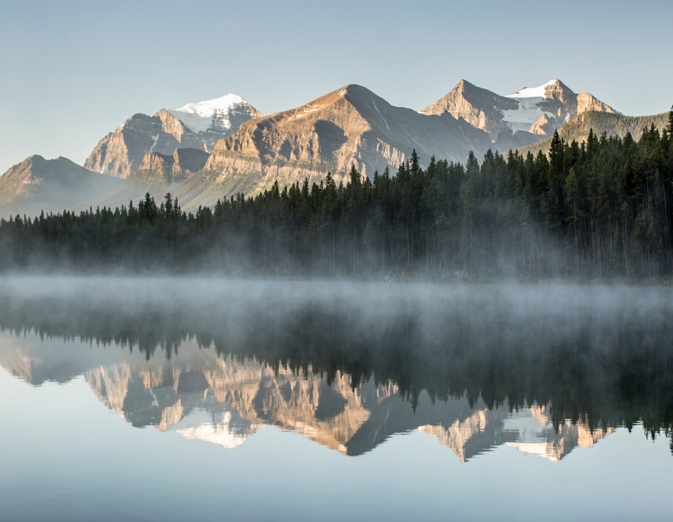 Canadian Rockies behind a misty lake in Banff, Alberta