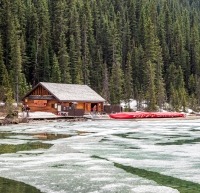 A cabin at Lake Louise with red canoes outside it