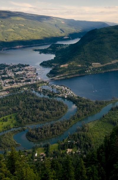 Shuswap Lake surrounded by mountains and greenery.