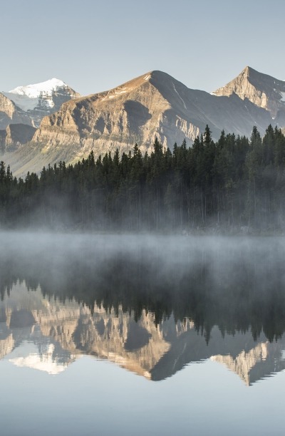 Serene reflection of the mountains in a lake at Banff National Park, near Lake Louise.