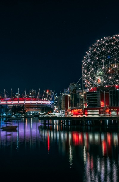 Lights of downtown Vancouver at night, with Rodgers Arena and Science World in frame